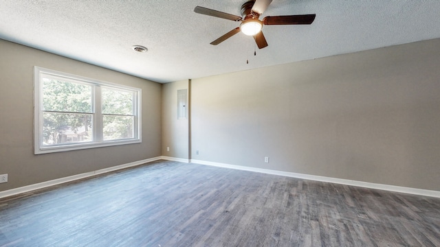 empty room featuring ceiling fan, a textured ceiling, and dark wood-type flooring