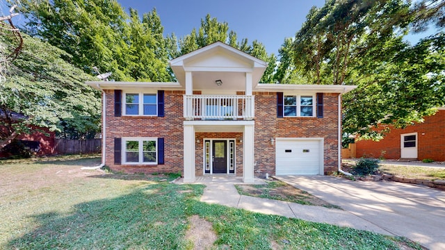 view of front of home featuring a balcony, a front yard, and a garage