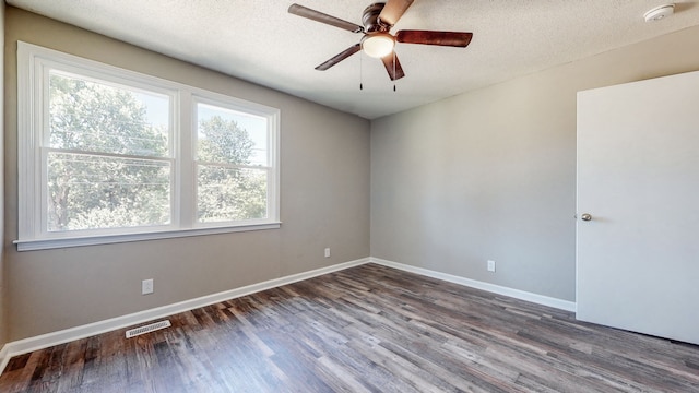 spare room with a textured ceiling, ceiling fan, and dark hardwood / wood-style flooring