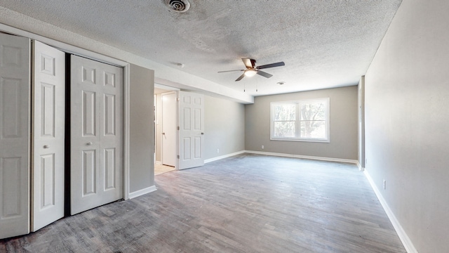 unfurnished room with a textured ceiling, ceiling fan, and light hardwood / wood-style flooring