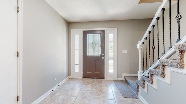 tiled foyer entrance featuring a textured ceiling and a healthy amount of sunlight