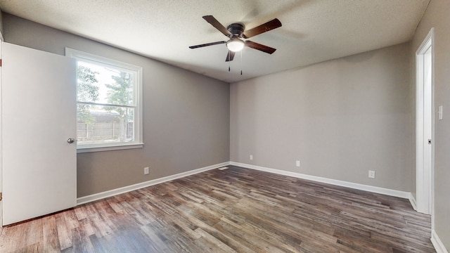 empty room featuring ceiling fan, dark hardwood / wood-style floors, and a textured ceiling