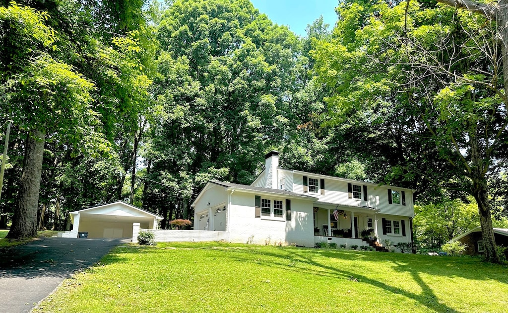 view of front of property featuring a front lawn, an outdoor structure, and a garage