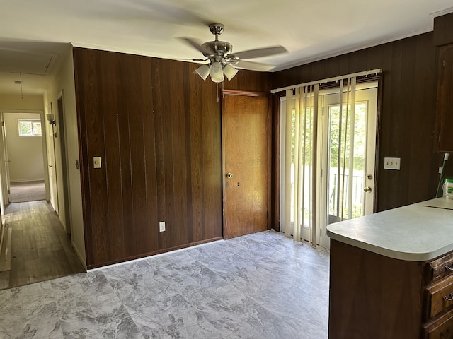 interior space with wooden walls, ceiling fan, and light tile floors