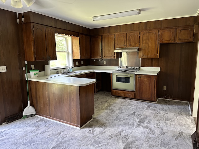 kitchen with light tile floors, kitchen peninsula, white range, ceiling fan, and sink