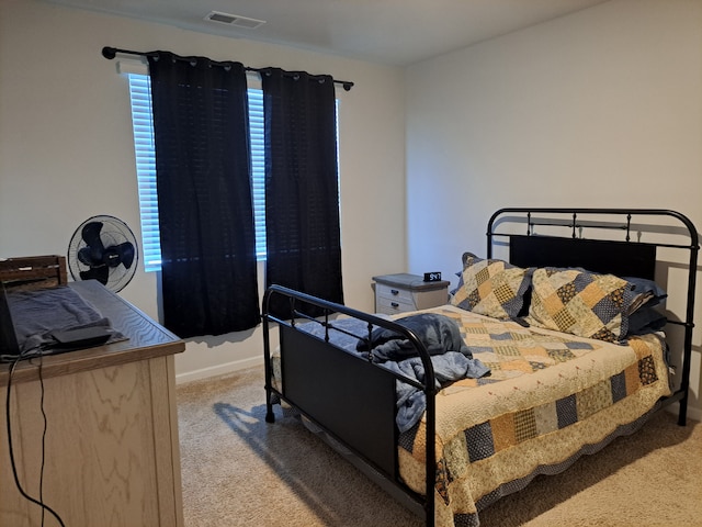 bedroom with light carpet and multiple windows