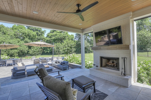 view of terrace featuring an outdoor living space with a fireplace and ceiling fan