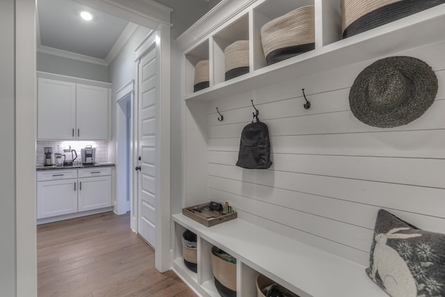 mudroom featuring ornamental molding and light hardwood / wood-style floors