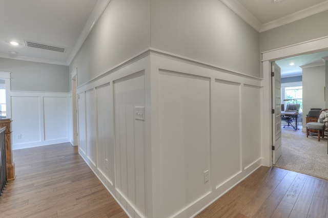 hall with light colored carpet and ornamental molding