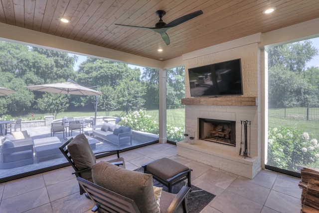 view of terrace featuring ceiling fan and an outdoor living space with a fireplace