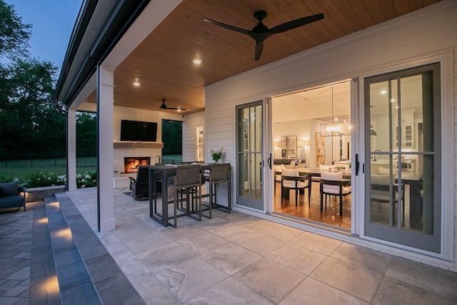 view of patio with an outdoor fireplace and ceiling fan