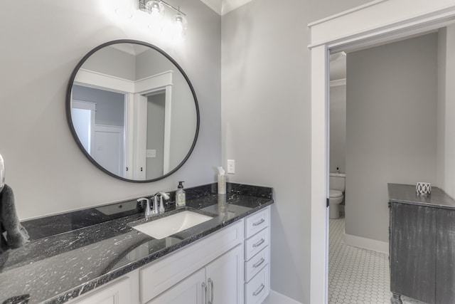 bathroom featuring vanity, tile flooring, and toilet