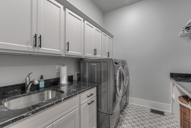 clothes washing area featuring light tile flooring, cabinets, sink, washer hookup, and washer and dryer