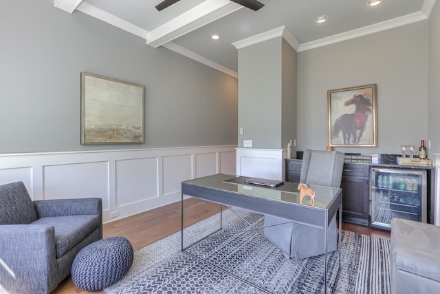 office with ceiling fan, beamed ceiling, beverage cooler, hardwood / wood-style flooring, and ornamental molding