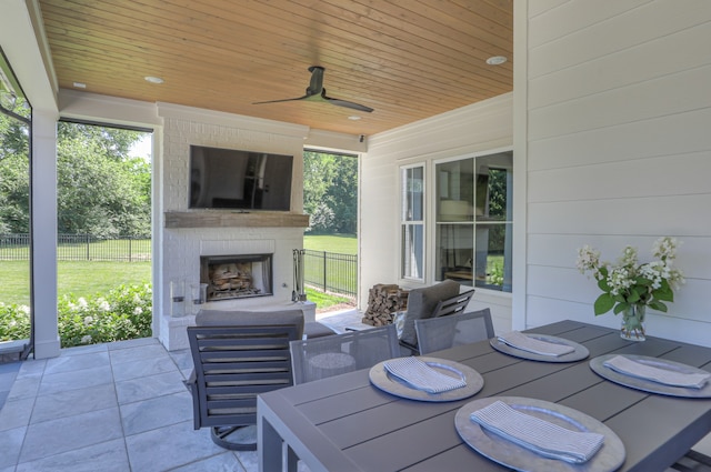 view of terrace featuring a fireplace and ceiling fan