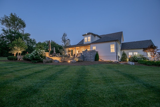 rear view of property featuring a lawn