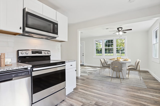 kitchen featuring backsplash, ceiling fan, appliances with stainless steel finishes, light hardwood / wood-style floors, and white cabinets