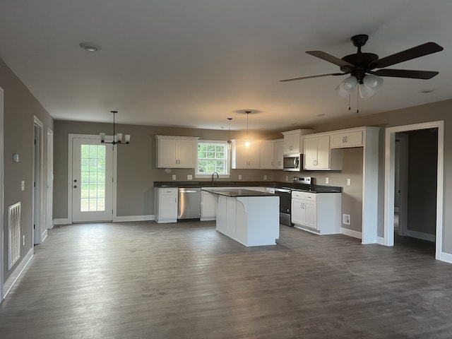 kitchen featuring dark hardwood / wood-style floors, appliances with stainless steel finishes, decorative light fixtures, and white cabinetry