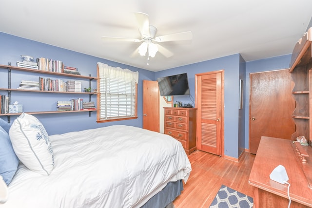 bedroom with ceiling fan, light hardwood / wood-style floors, and a closet