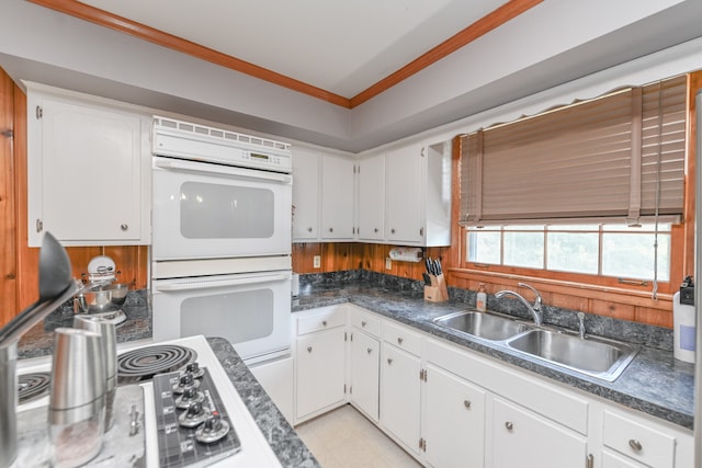 kitchen with white double oven, sink, light tile floors, white cabinets, and crown molding