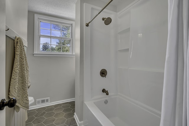 bathroom featuring toilet, shower / tub combo, a textured ceiling, and tile flooring