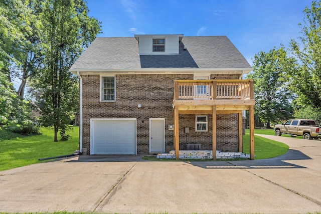 view of front of property featuring a balcony, a front yard, central air condition unit, and a garage