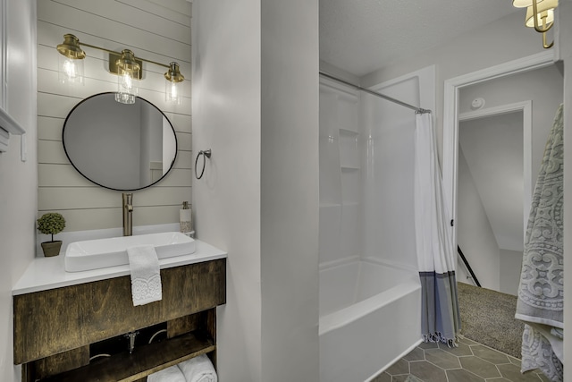 bathroom with shower / bath combo with shower curtain, a textured ceiling, tile flooring, and vanity