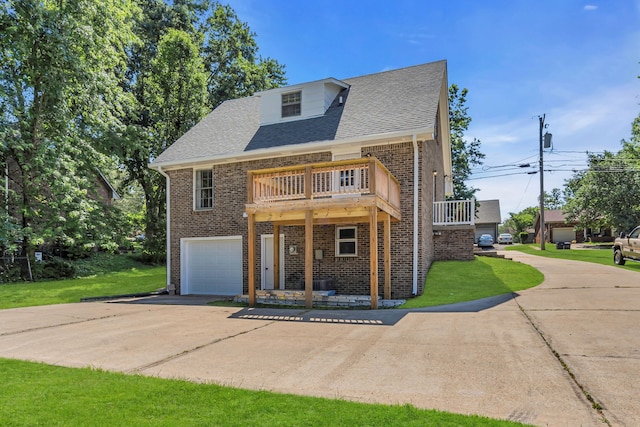 view of front of home with a balcony, a front yard, and a garage