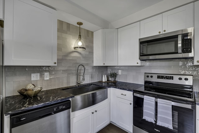 kitchen with white cabinets, tasteful backsplash, decorative light fixtures, and appliances with stainless steel finishes