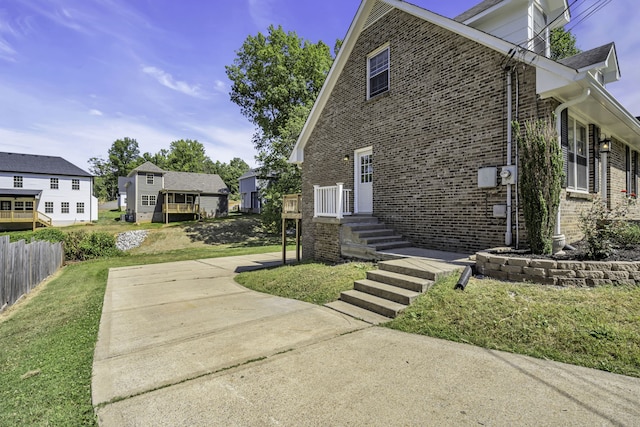 view of side of property featuring a deck and a yard