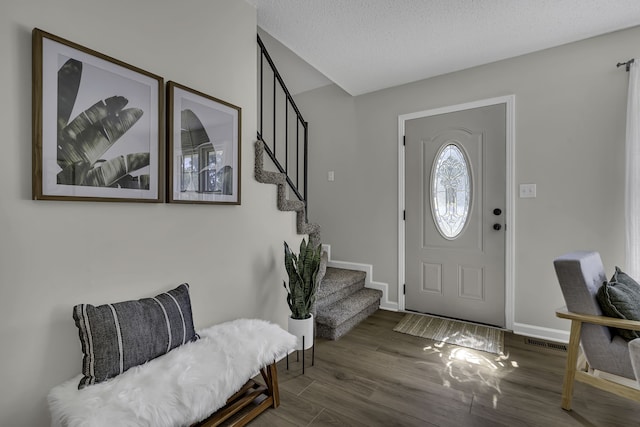 foyer featuring dark wood-type flooring and a textured ceiling