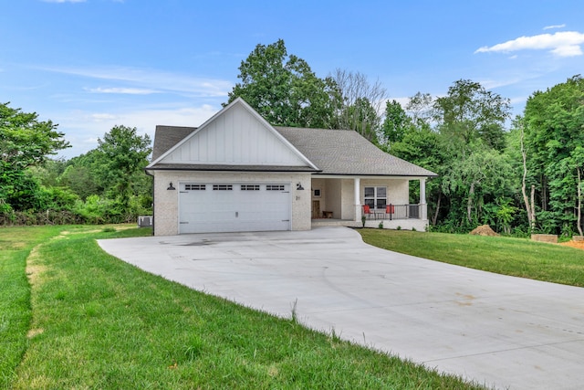 view of front of property with a porch, a front lawn, and a garage