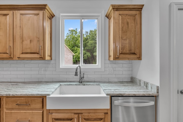 kitchen featuring light stone countertops, sink, tasteful backsplash, and dishwasher