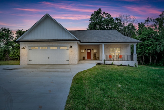 view of front of house featuring a lawn, a porch, and a garage