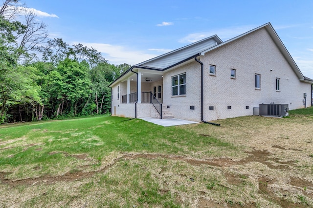 rear view of house with a lawn, a patio, and central air condition unit