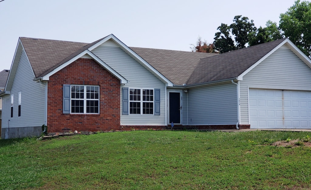 single story home with a front yard and a garage