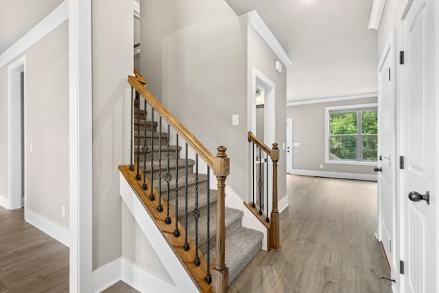 stairway featuring light hardwood / wood-style flooring and ornamental molding