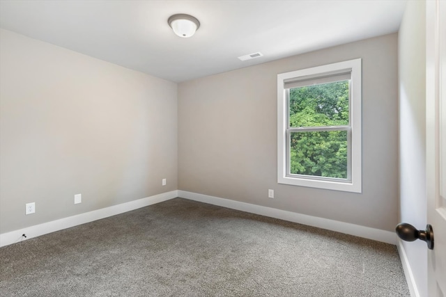 spare room featuring dark colored carpet