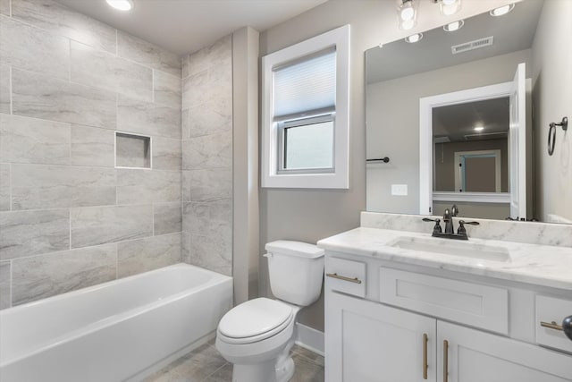 full bathroom with tile floors, toilet, vanity, and tiled shower / bath