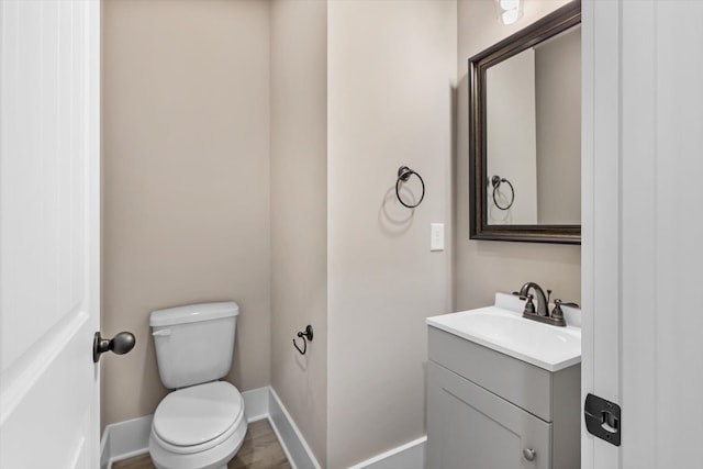 bathroom featuring vanity, hardwood / wood-style floors, and toilet