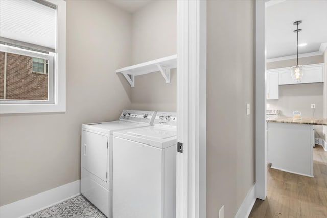 washroom with crown molding, light wood-type flooring, and washing machine and dryer