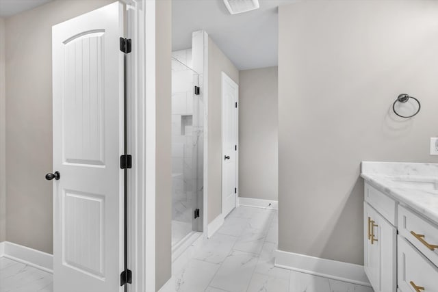 bathroom featuring a tile shower, vanity, and tile flooring