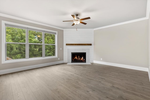 unfurnished living room with crown molding, dark hardwood / wood-style flooring, and ceiling fan