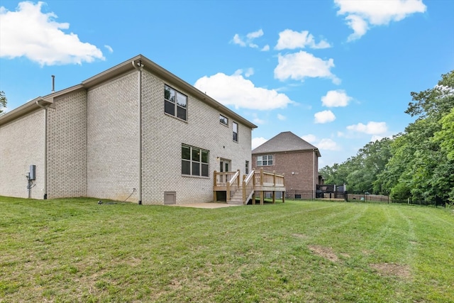 back of house with a wooden deck and a yard