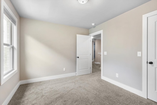 unfurnished room featuring light carpet