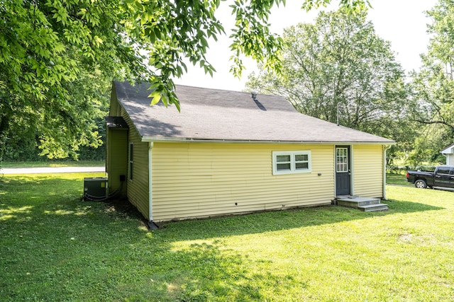 rear view of house with a lawn and central AC