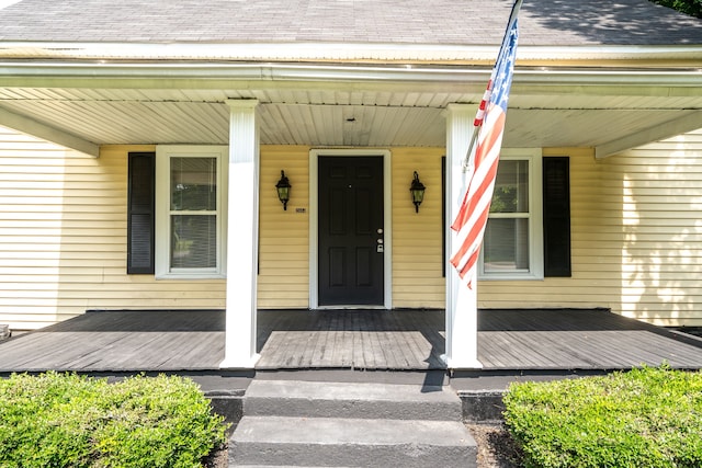 view of exterior entry featuring covered porch