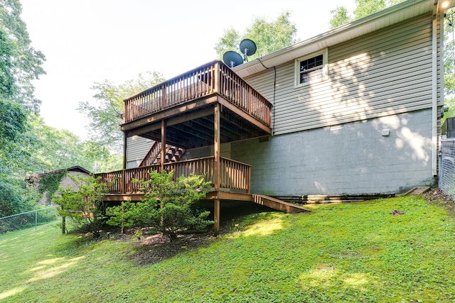 back of property with a wooden deck and a lawn