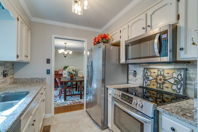 kitchen with appliances with stainless steel finishes, white cabinets, a chandelier, light stone counters, and tasteful backsplash