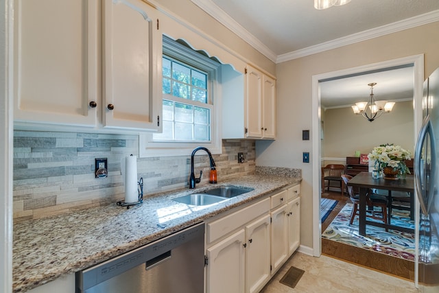 kitchen featuring appliances with stainless steel finishes, sink, white cabinets, a chandelier, and tasteful backsplash